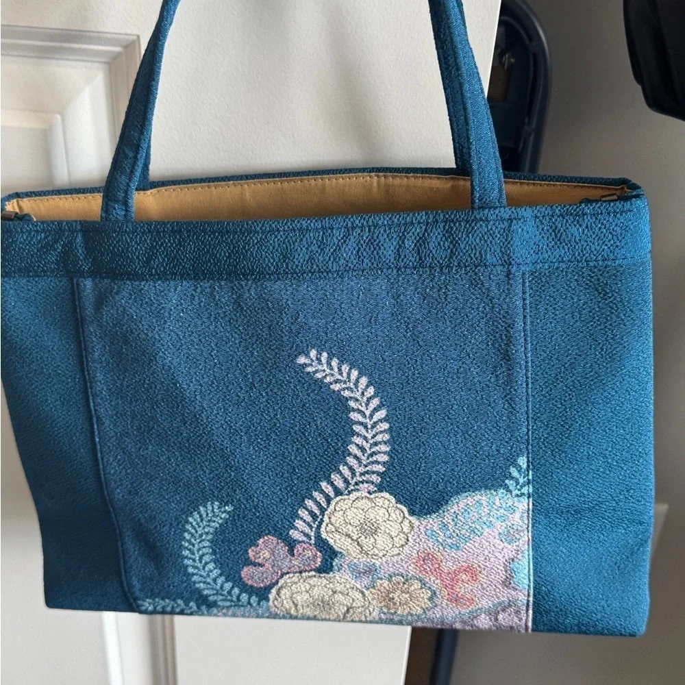 Teal-colored‎ handbag bag featuring intricate floral embroidery
